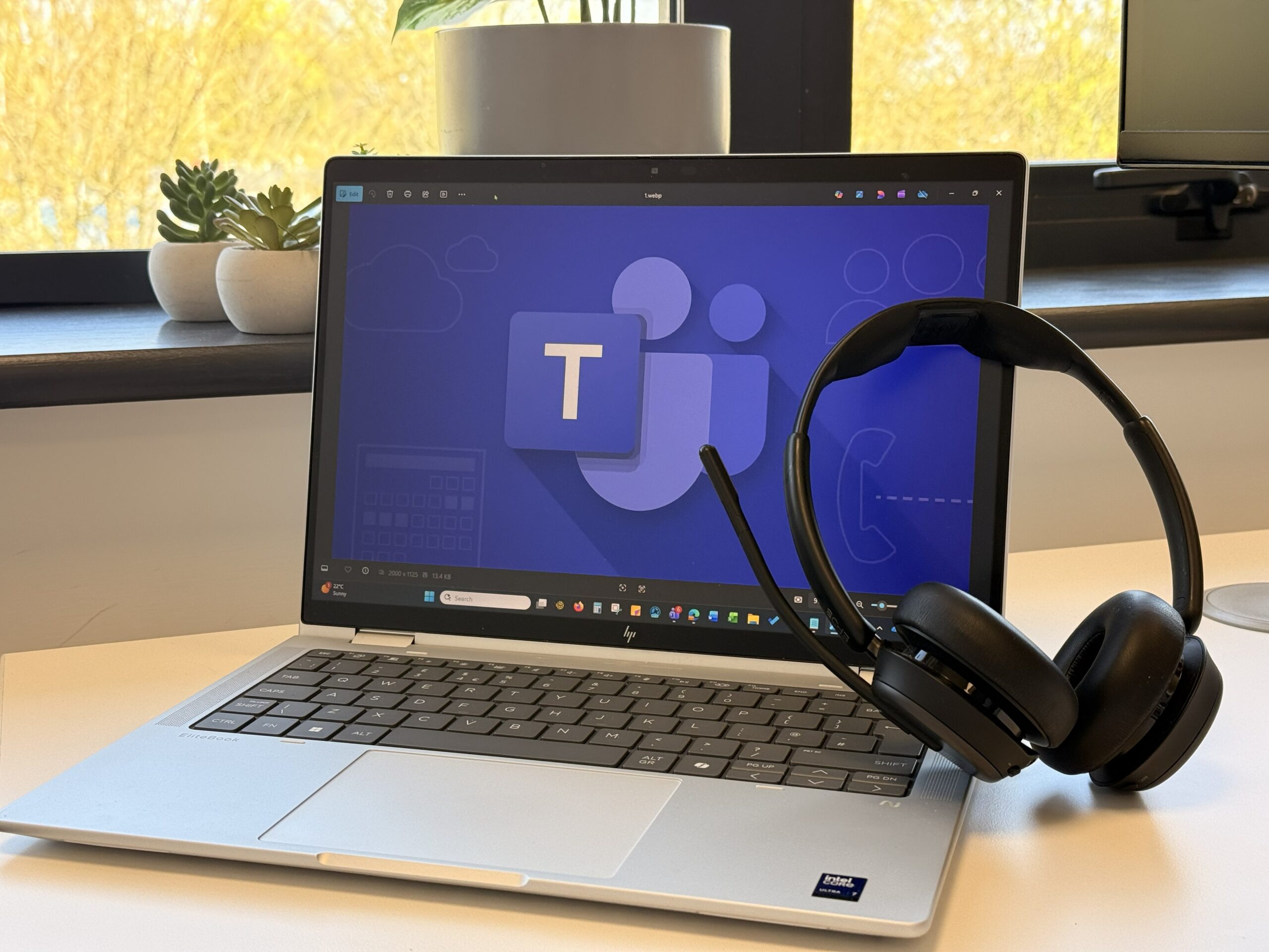Microsoft Teams Phone logo displayed on a laptop with headphones leaning on it
